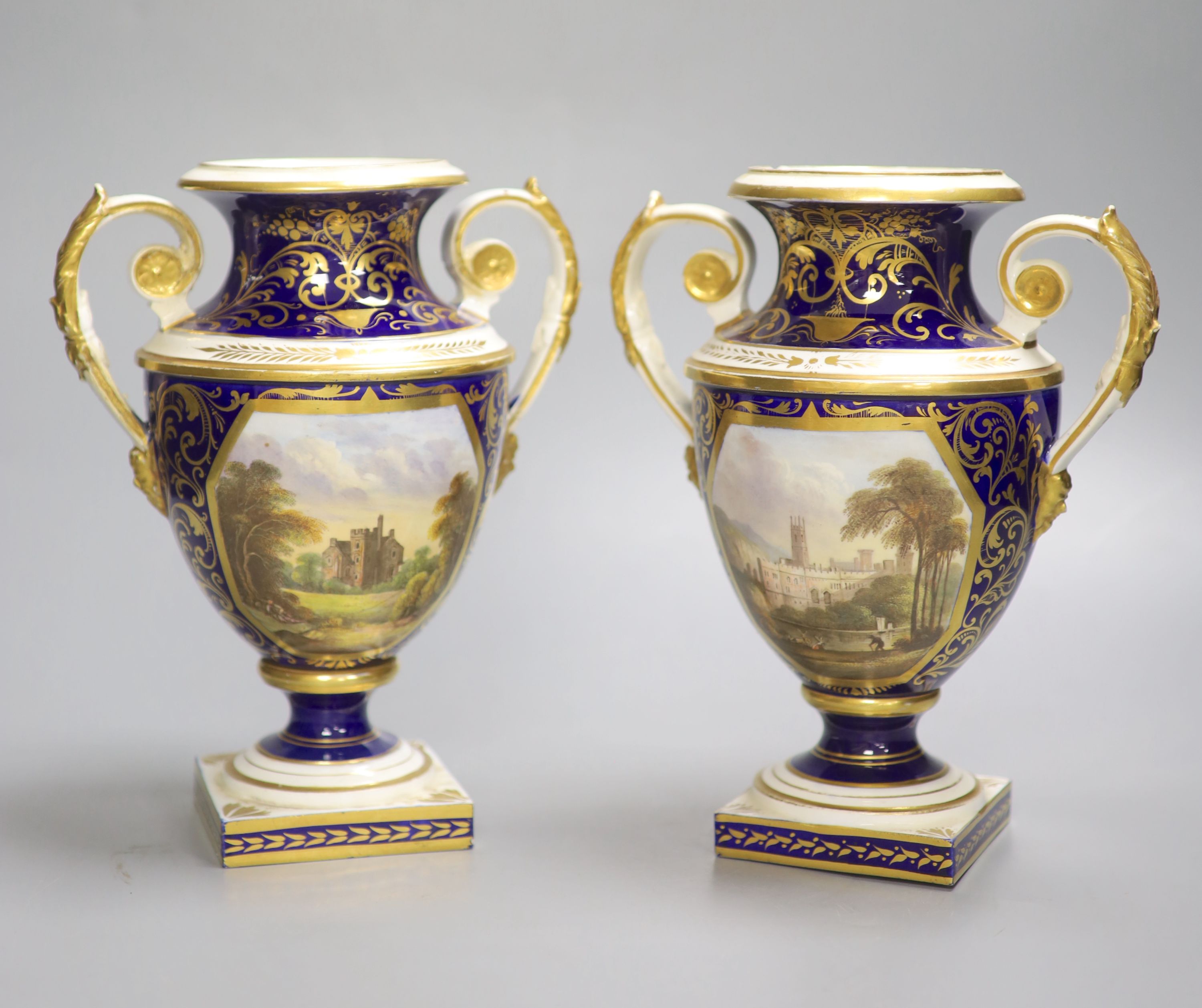 A Derby pair of two handled shield vases, painted with scenes of Old Castle Oxenford and Warwick Castle, height 22cm